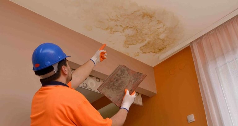 professional pointing out a water leak in roof; how long does a roof last