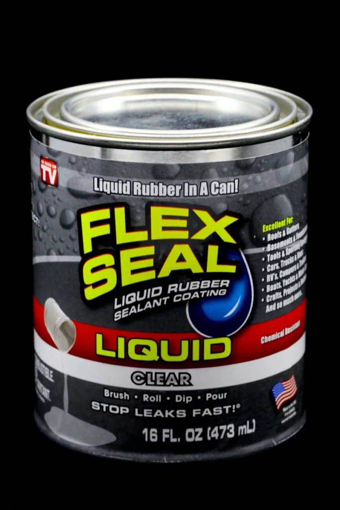 A can of Flex Seal Liquid Rubber Sealant Coating (clear), 16 fl. oz (473 mL), labeled with product info and usage instructions. Shown on a black background, it's known as one of the best roof sealants for leaks.