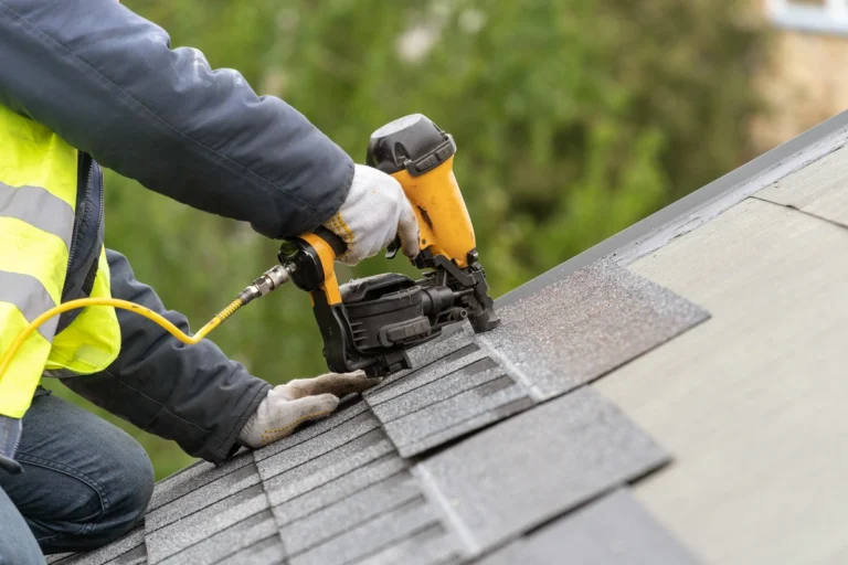 professional worker installing roof shingles