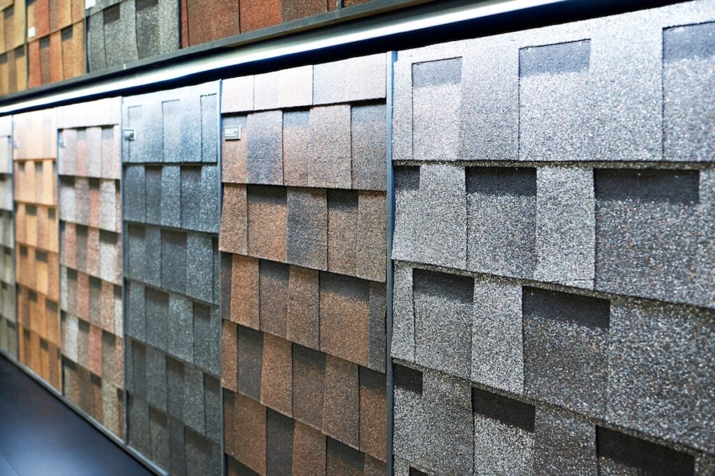 Display of various CertainTeed shingle colors and textures, arranged vertically on a showroom wall for easy comparison.