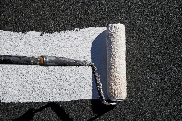 A roller applying roof coating