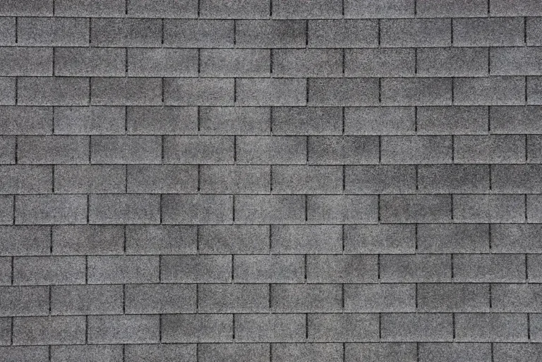 Close-up view of a gray asphalt shingle roof, showing a uniform pattern of rectangular shingles arranged in horizontal rows—ideal for learning how to replace missing shingles seamlessly.