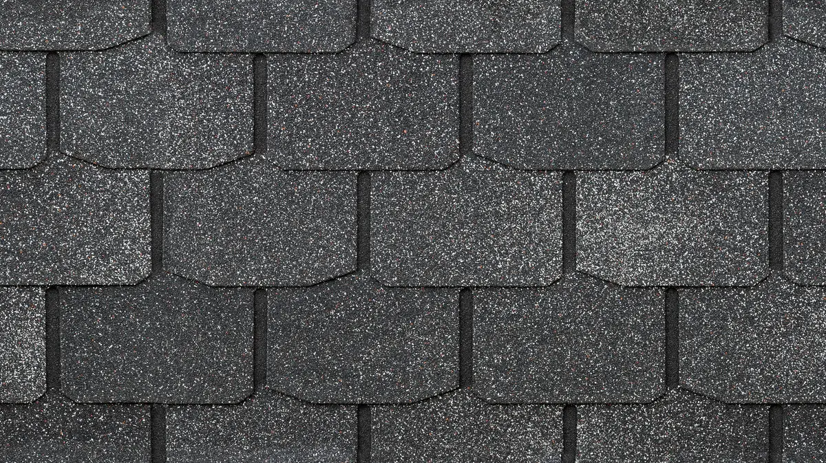 Close-up view of overlapping dark gray asphalt roof shingles with a rough, textured surface and hexagonal pattern—ideal for learning how to replace missing shingles efficiently.