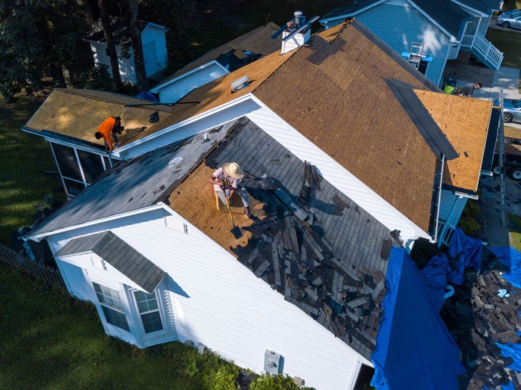 roofers replacing roof with asphalt shingles