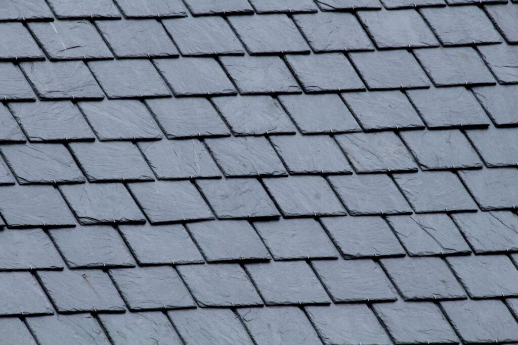 Close-up view of a roof covered with overlapping dark gray slate tiles arranged in a uniform, diagonal pattern—quality craftsmanship from roofing Springfield experts.