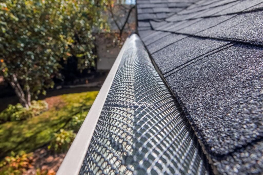 A close-up of a wire mesh gutter guard installed on a residential roof.