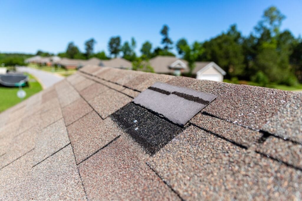 A residential roof with an area of damaged or missing shingles.